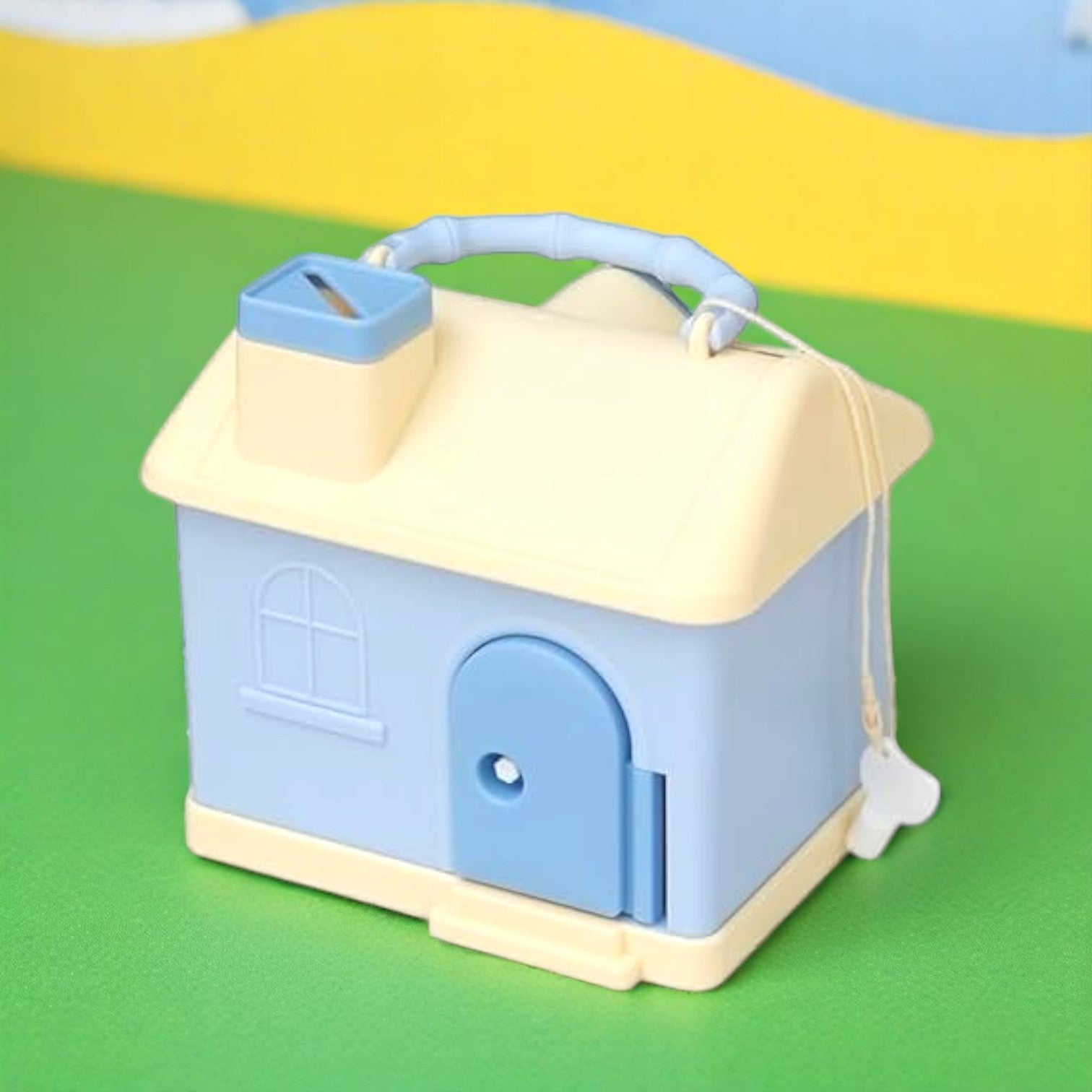 Kids' house money bank with lock, key, and 3D sticker compatibility, in pastel pink and blue. www.usmile.toys